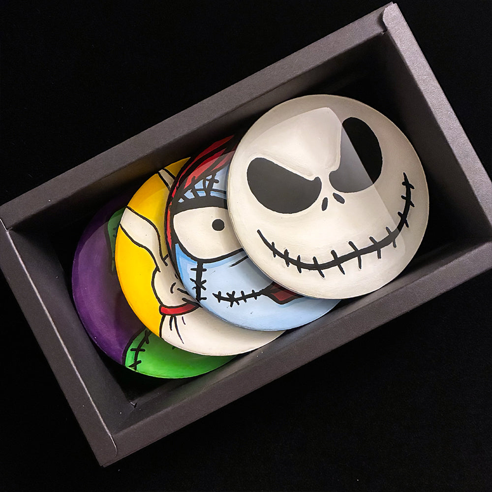 Set of colorful coasters with characters faces in a box on a black background