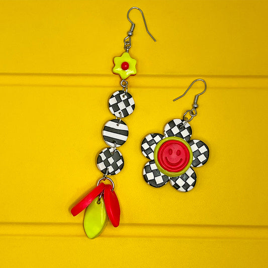 Lee's Art Studio smiley face checkered flower asymmetric pair of polymer clay earrings with lineal pattern and neon color details.